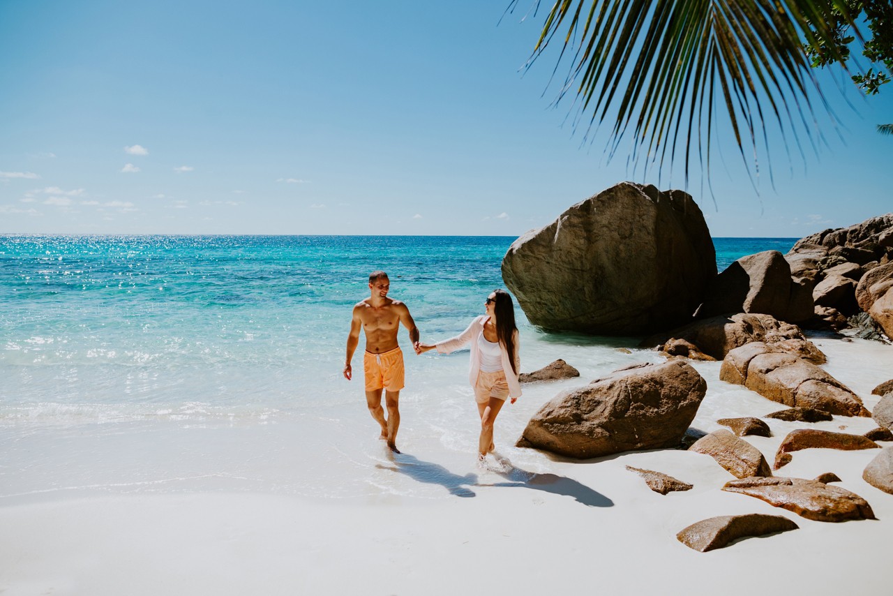 couple relax on beach resort in tropics. Luxury travelling together. Seychelles.