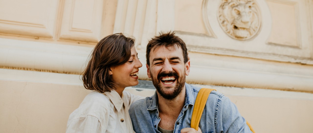 Shot of a happy young couple laughing and talking while exploring a foreign city.