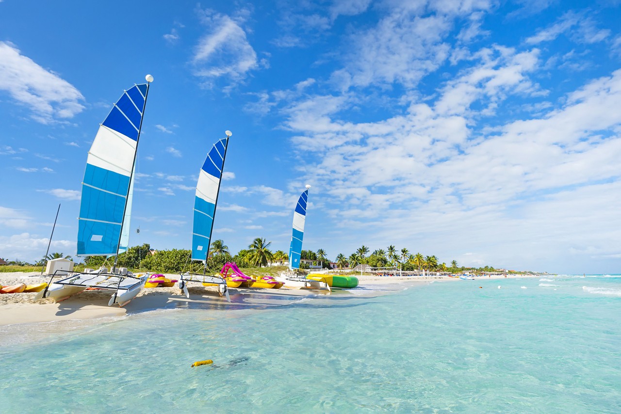 beautiful paradise beach of Varadero in Cuba on a sunny summer day. Beautiful seascape with clear turquoise water. sailing ships are parked on the sand.