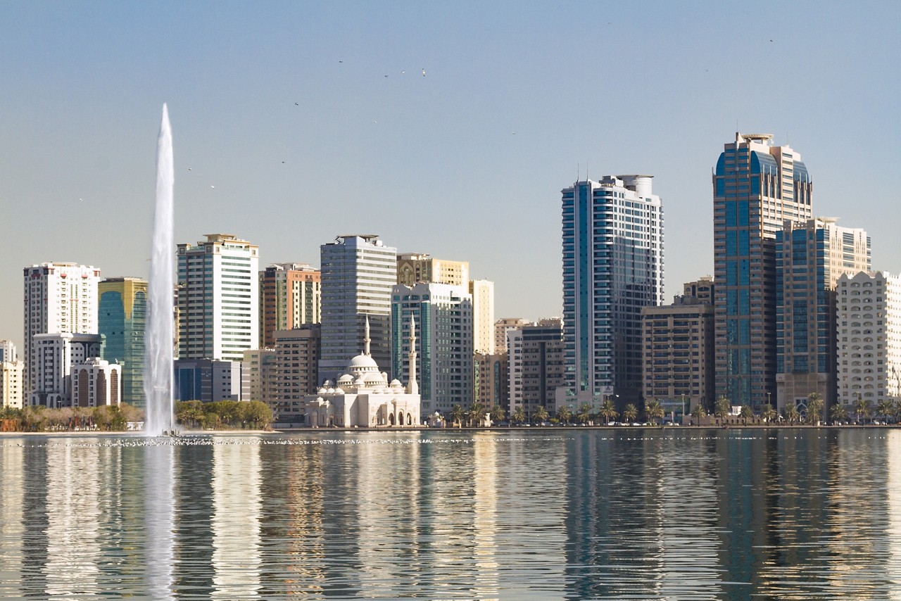 Noor Mosque and jet stream in Khalid Lake, with the city skyline in the background,