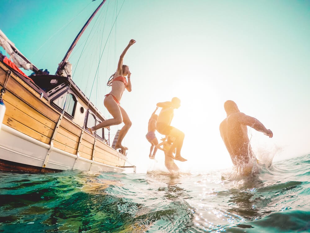 Ibiza Familienurlaub: Familie springt vom Boot ins Wasser.