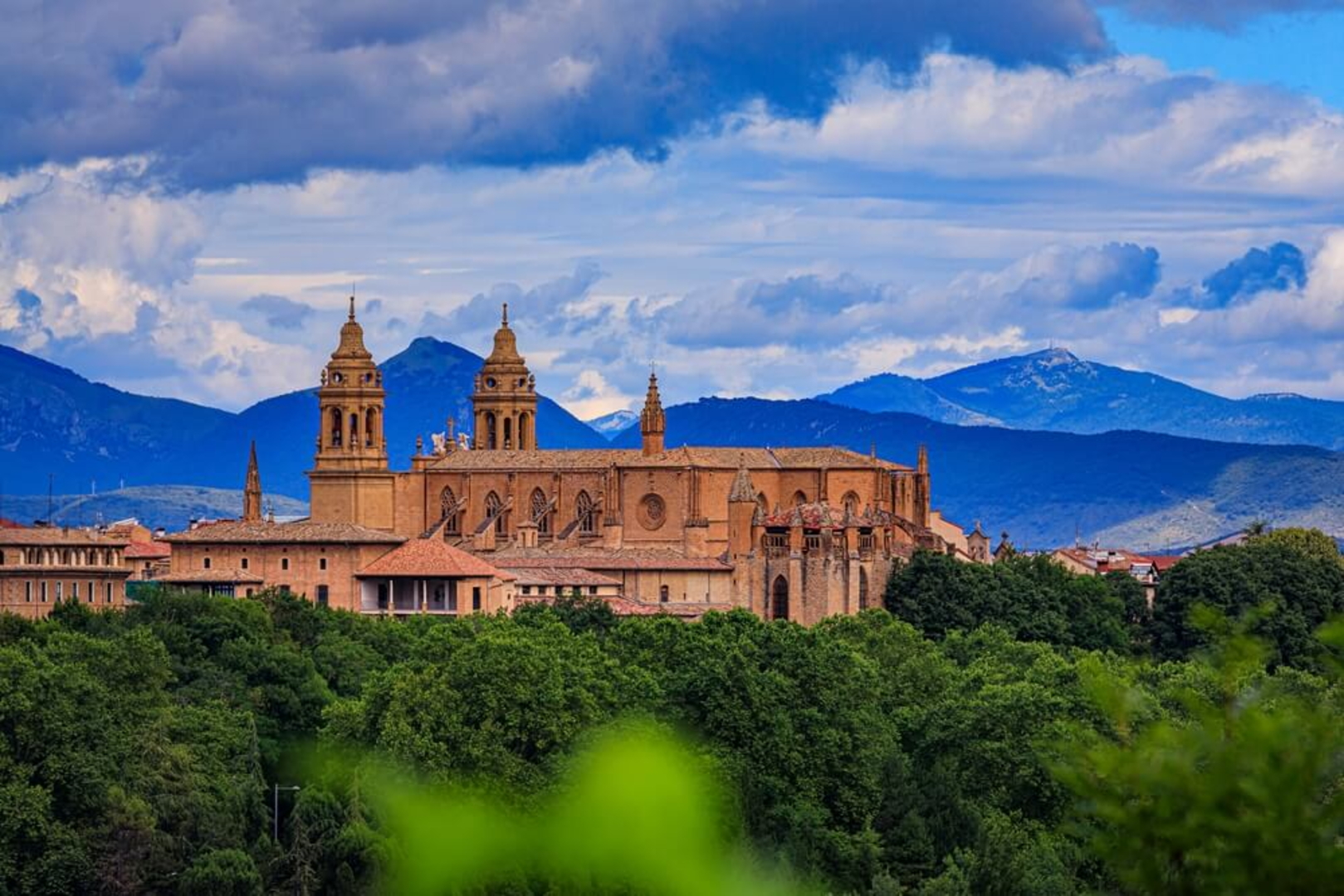 Pamplona Sehenswürdigkeiten: die Kathedrale von Weitem betrachtet hinter vielen Bäumen