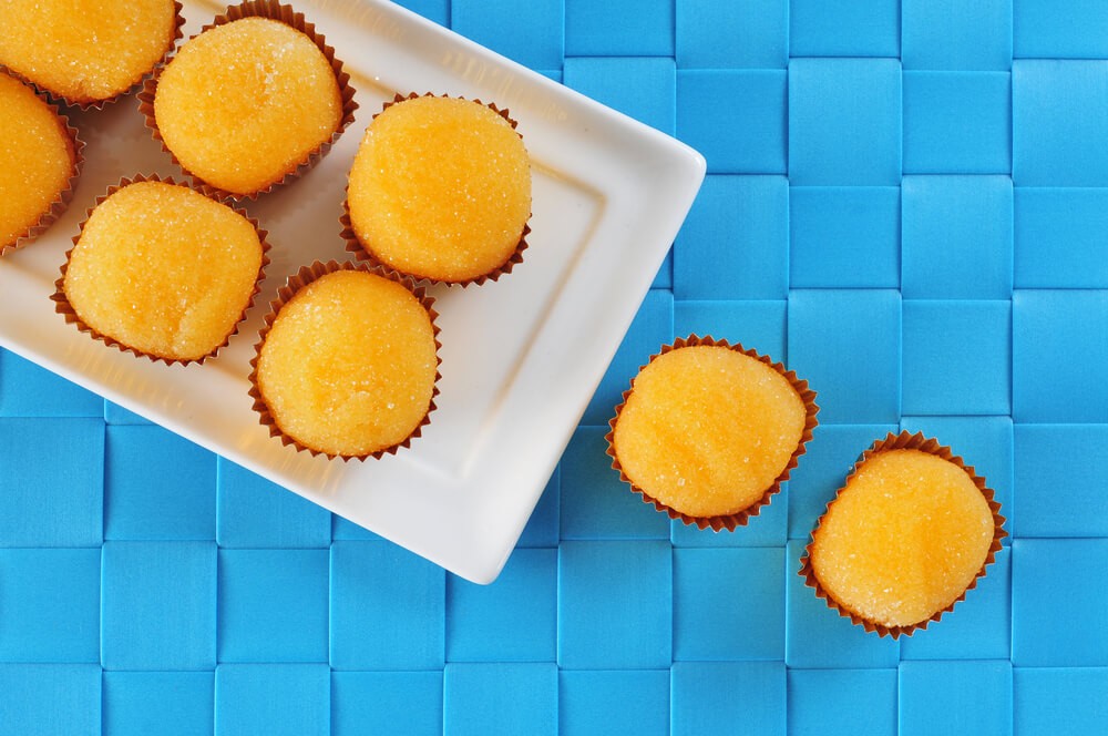 Yemas: Yellow sweets in red paper cups on a blue surface